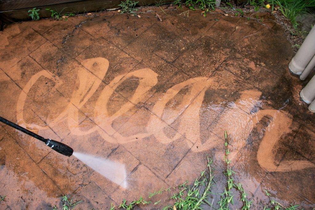 Cleaning backyard with pressure washer. Spring clean up